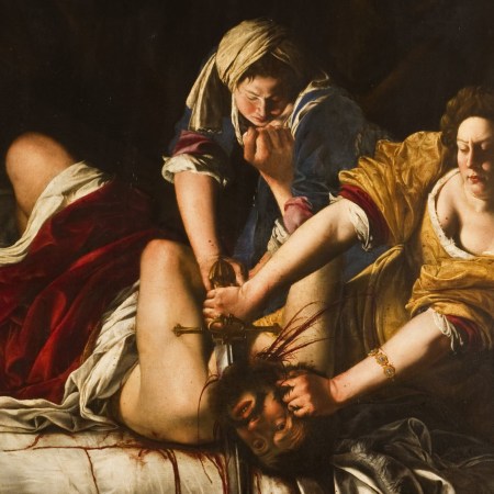 Two women holding down and decapitating a man on a bed